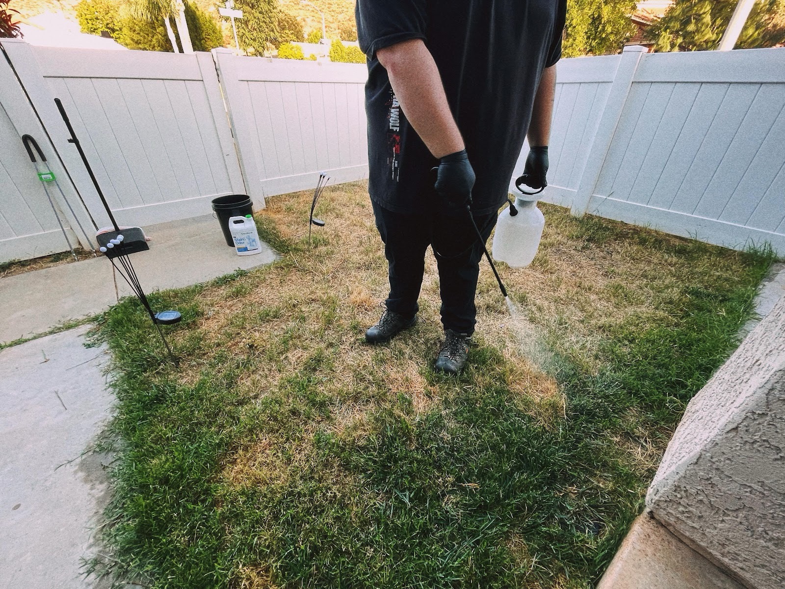 Stink Butts owner-operator spraying yard deodorizer on the lawn